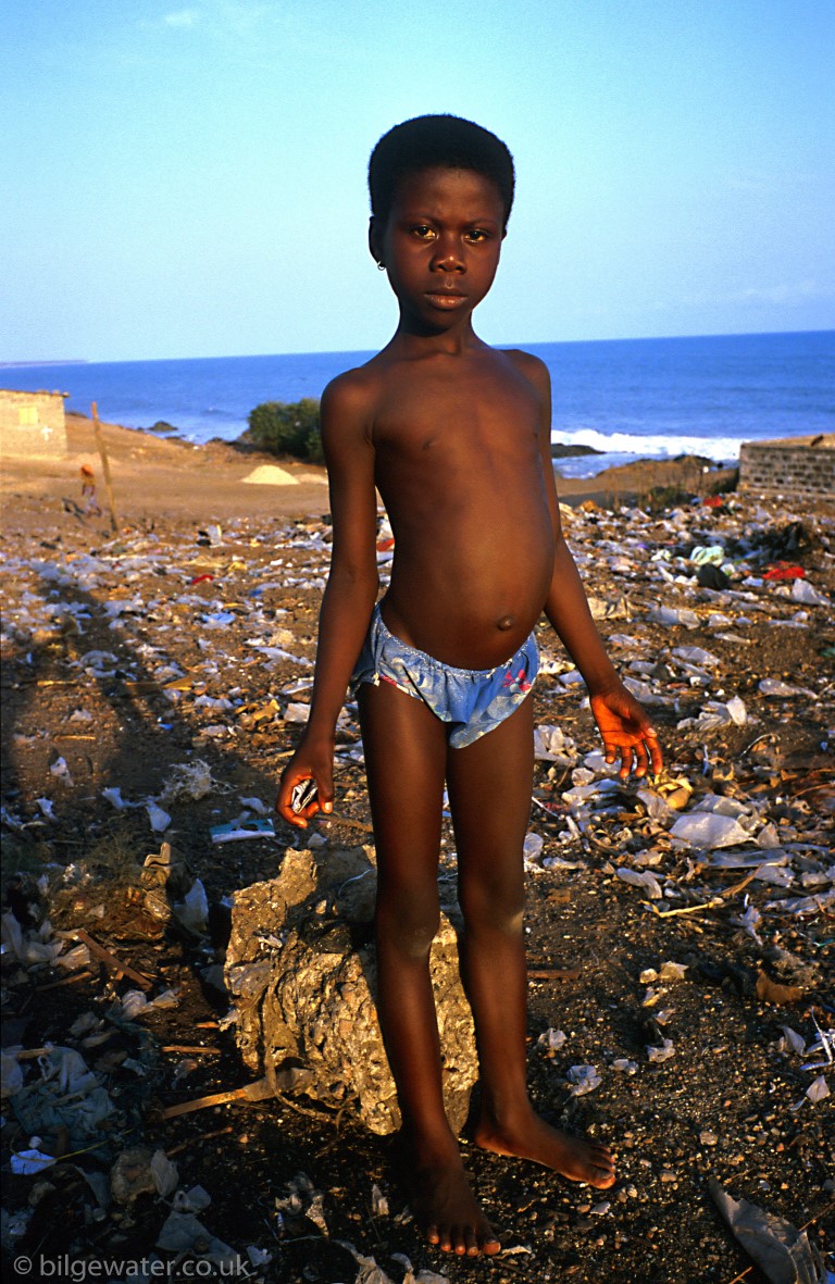 Girl scavenging on rubbish tip, Winneba, Ghana, West Africa